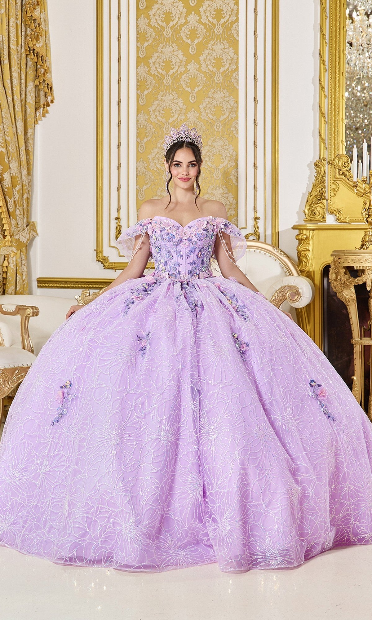 A woman in the lilac Quinceanera Dress 5127 by Dancing Queen, featuring beaded floral details and a tiara, stands in an ornate room with gold decor and antique furniture.